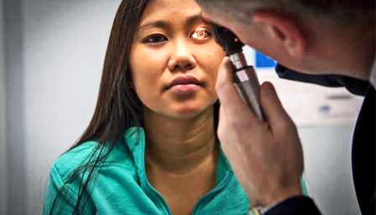 A doctor checks a young athlete's vision