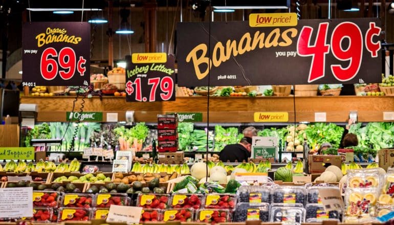 price signs like "Bananas 49c" hang over produce section