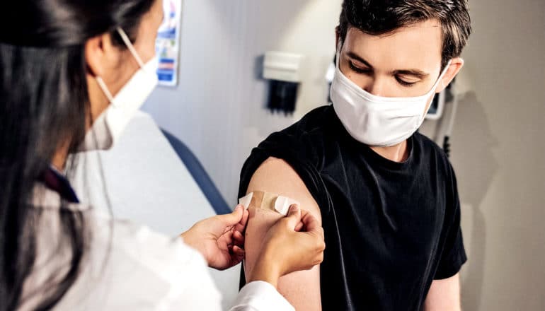 A young man gets an HPV vaccine at the doctor's office