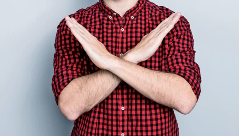 person crossing arms over chest to say no