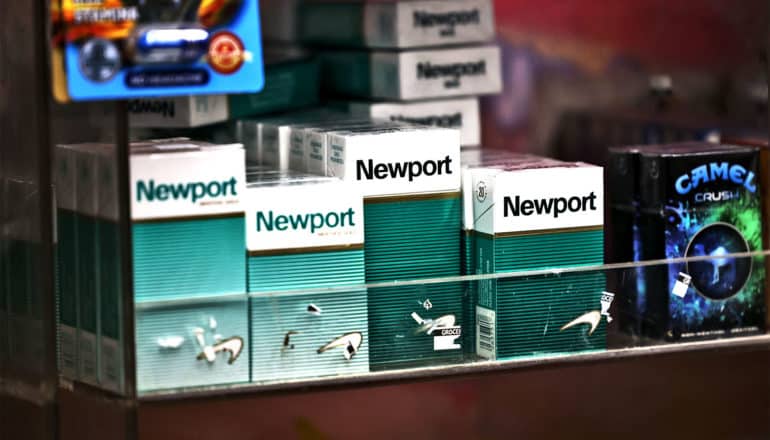 Packs of menthol cigarettes sit on a shelf at a convenience store