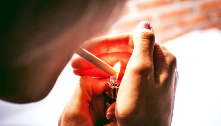 A woman lights a cigarette