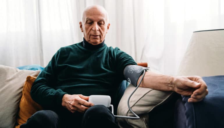 older adult uses home blood pressure cuff