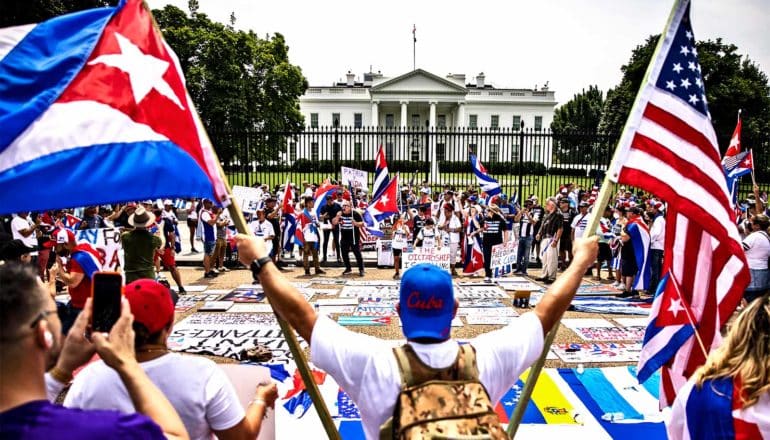 A protestor holds up the American and Cuban flag at a protest outside the White House