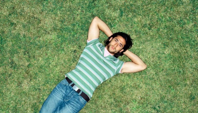 from above, person lies on grass staring upward