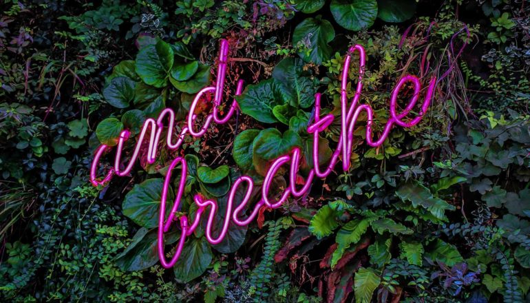 neon letters say "and breathe"