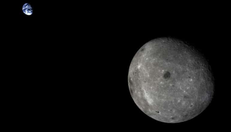 The moon in the foreground and the Earth in the background against the blackness of space