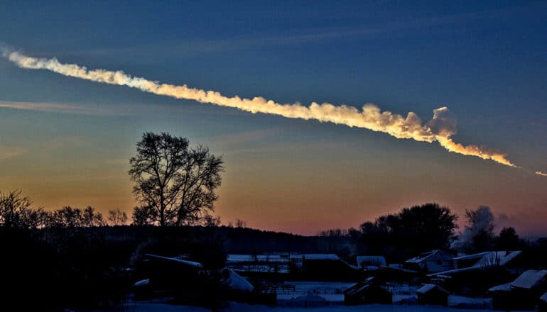 trail from meteor in sky over snowy landscape