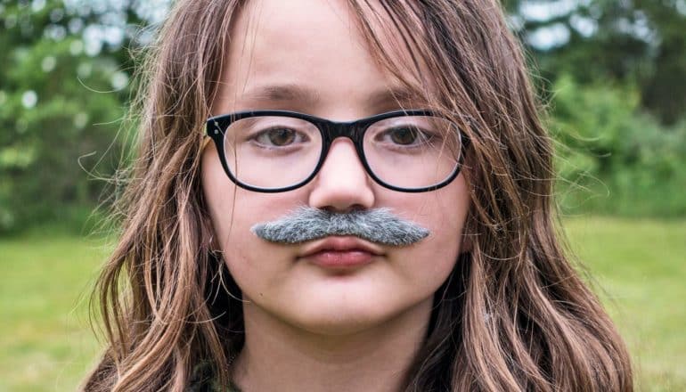 inscrutable kid in glasses and fake moustache