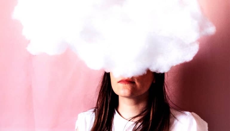 A woman's face is covered by a white cloud