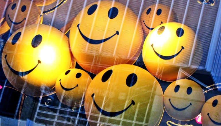 Yellow smiley faces hang in the window of a store