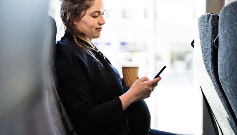 pregnant person on bus with coffee