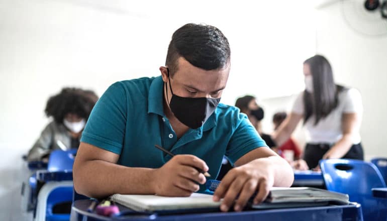 student at desk in mask