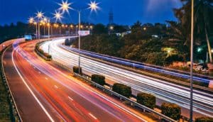 A blur of red and white lights on a highway at dusk