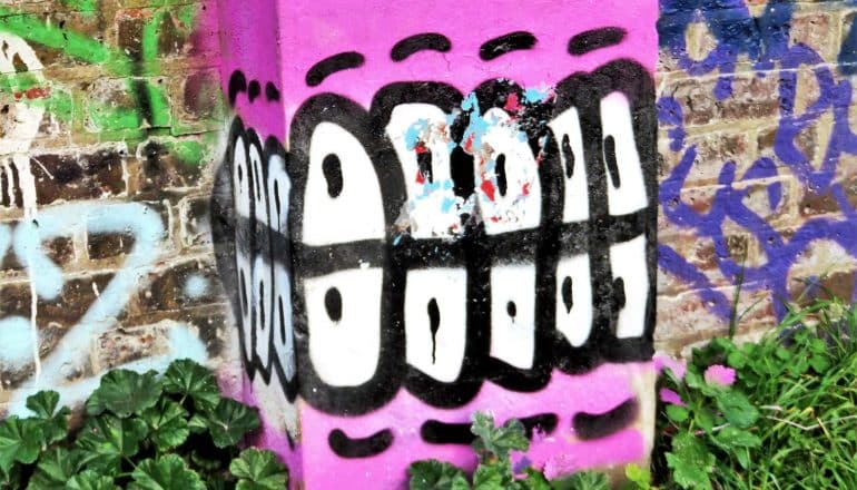 Street art shows white teeth and pink gums