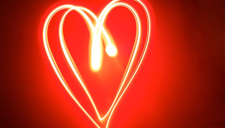 A heart shape created with white light on a red background