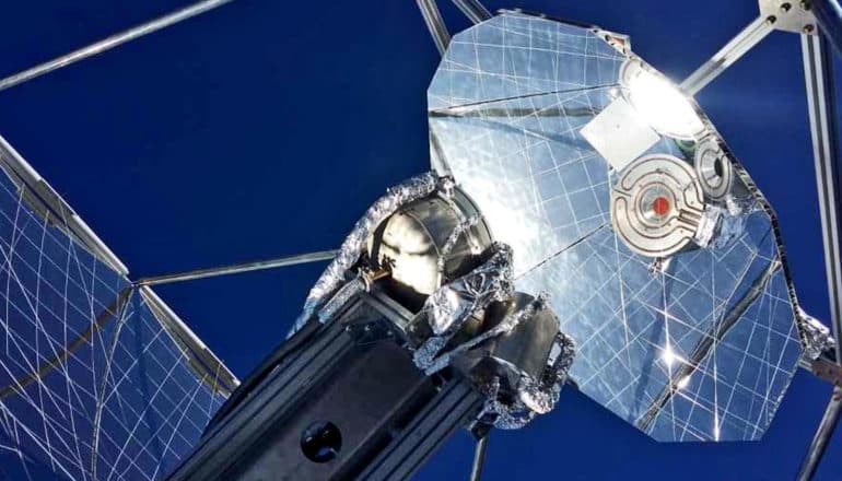 The solar refinery looks like a satellite dish with reflective panels on it against a blue sky