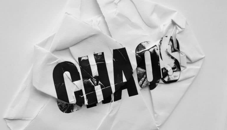 "chaos" stamped on crumpled paper