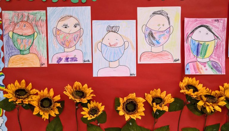 kids' drawings of themselves in masks with fake sunflowers