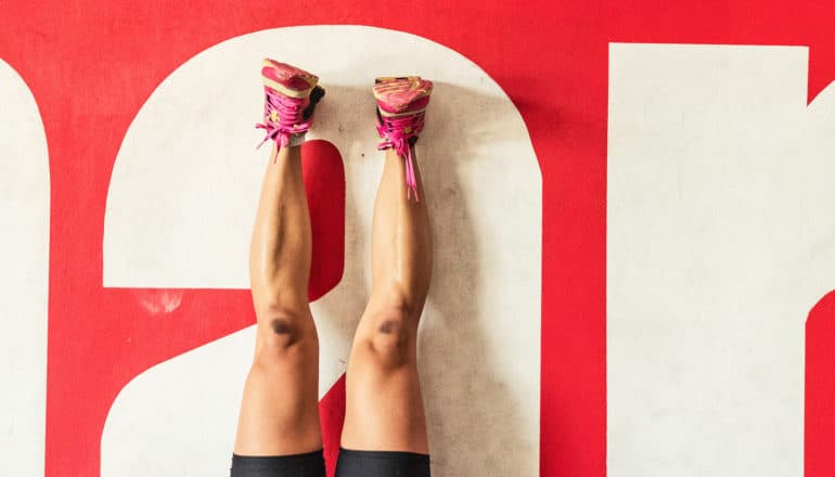 upside down legs with sneakers against wall