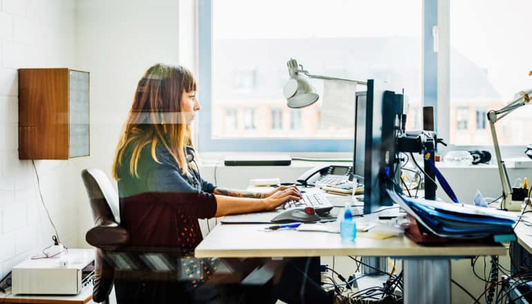 woman works at messy desk