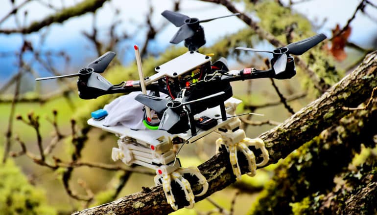 The bird robot looks like a drone with 4 helicopter-like rotors but it has talons like a bird to grasp a branch for perching