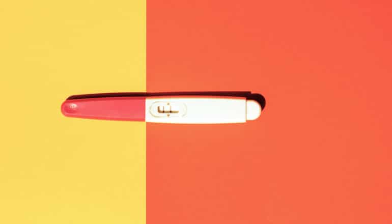 positive pregnancy test on colorful background