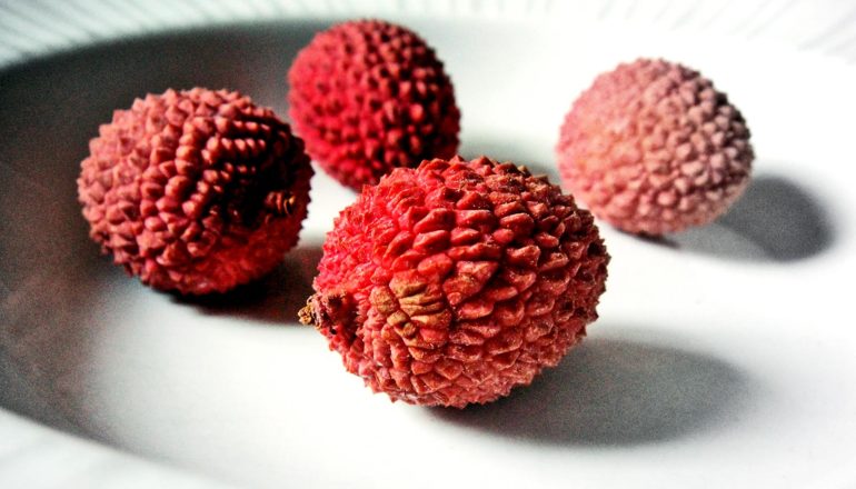 bumpy red fruit in white bowl