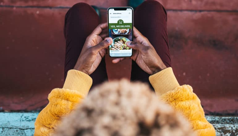 view from above, person orders food through app on phone