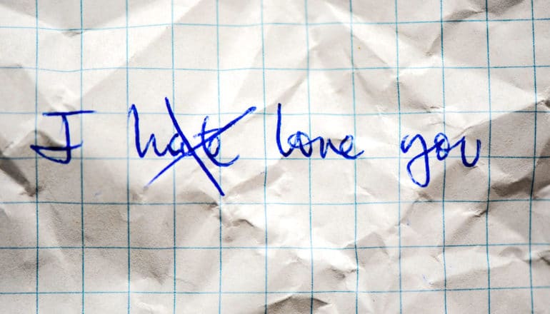 "I" then "hate" crossed out, then "love you" on crumpled paper in pen