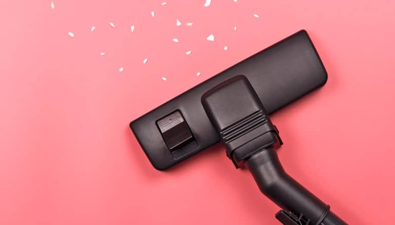 A black vacuum on a pink background