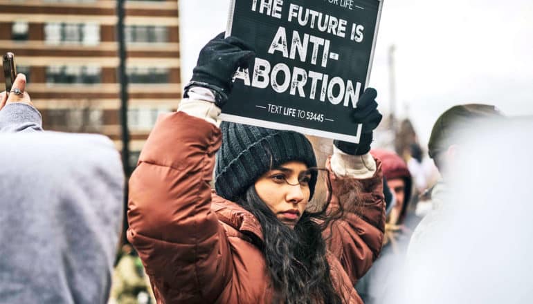 A protester holds a sign that reads "The Future is Anti-Abortion"