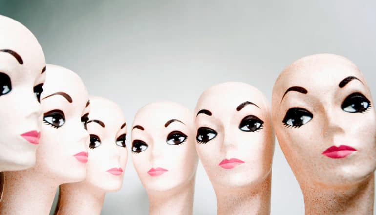 row of identical mannequin heads