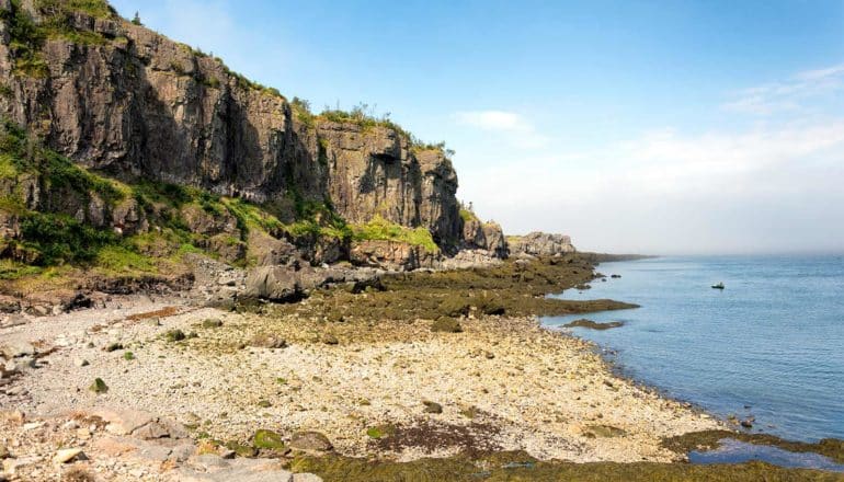 A coastline with a rocky cliff over the ocean