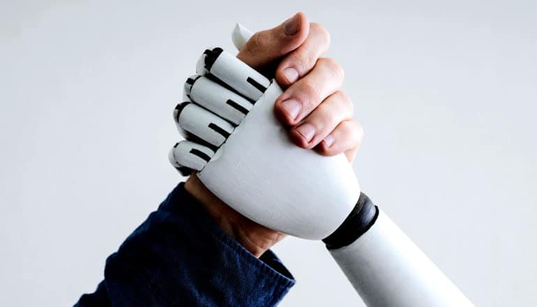 A human and robot clasp hands