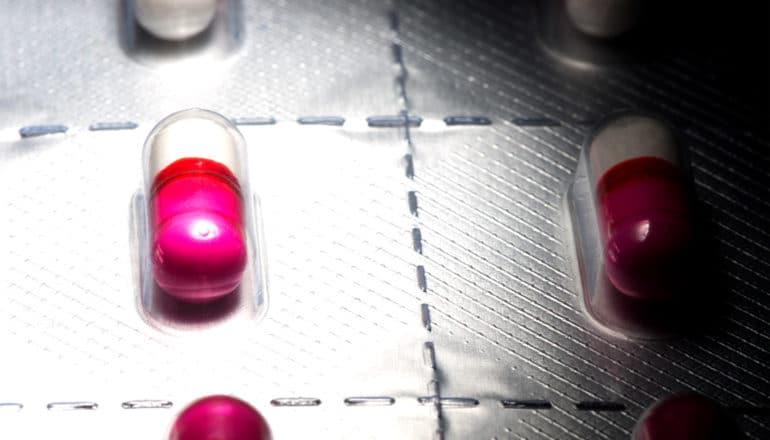 A plastic blister pack of pink and white antihistamine pills