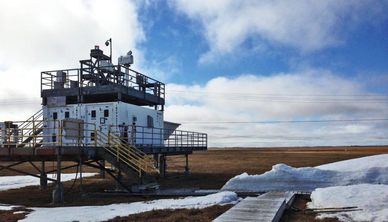 research station and wooden path in front of cloudy blue sky