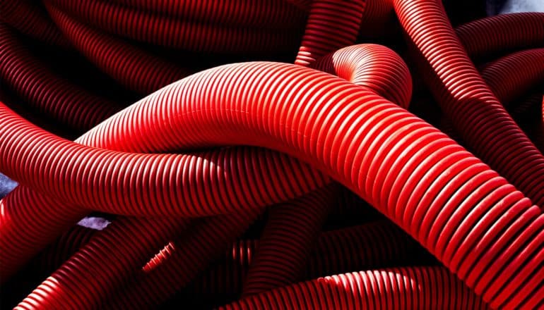 Red corrugated pipes tangled together