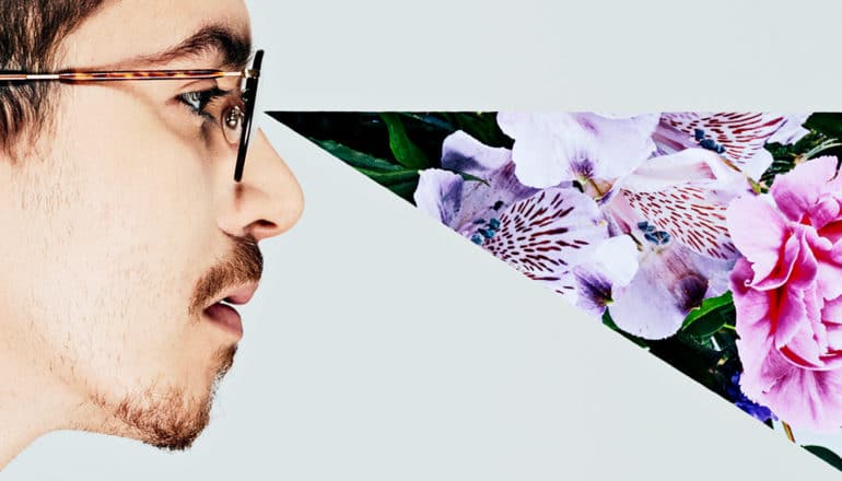 A man in profile with a collage of flowers making up a cone of vision