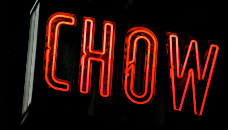 A red neon sign reads "Chow" at night