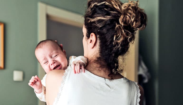 A woman holds her crying baby