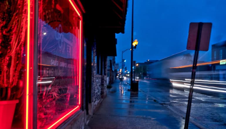 red light on window on busy city street at night