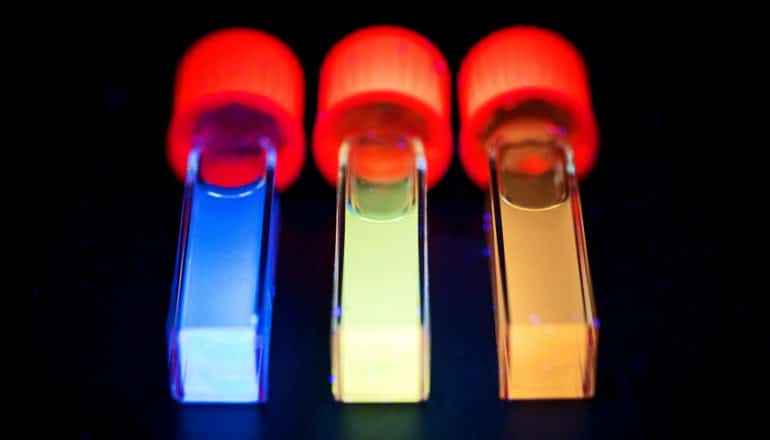 red-capped vials with glowing blue, green, orange contents