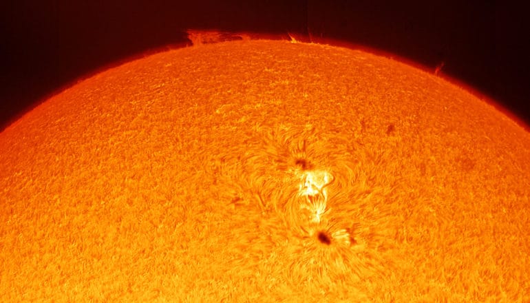 A close-up of the sun shows a white sunspot on the surface