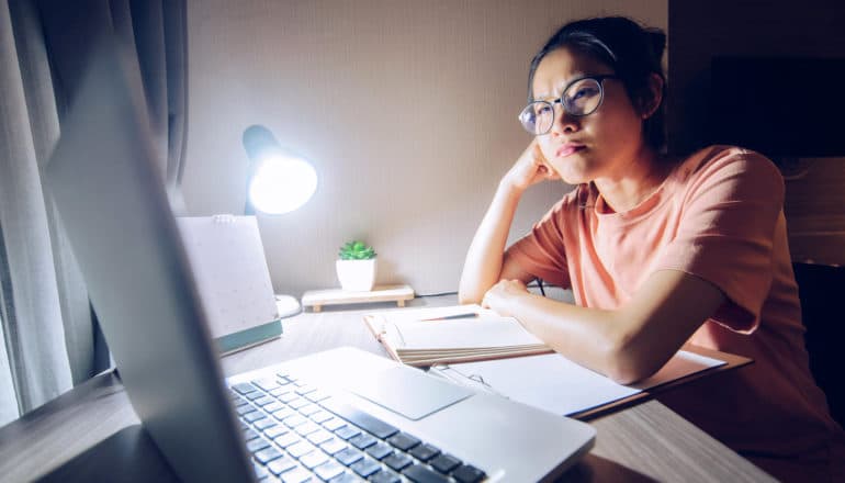 serious/upset woman at home desk at night