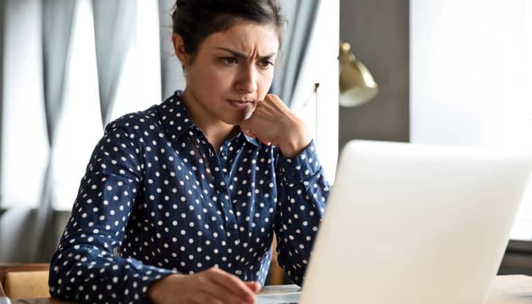 concerned person in dress shirt uses laptop