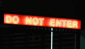 neon red "do not enter" sign in darkness