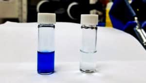 A vial of blue liquid next to a vial of clean, totally clear liquid.