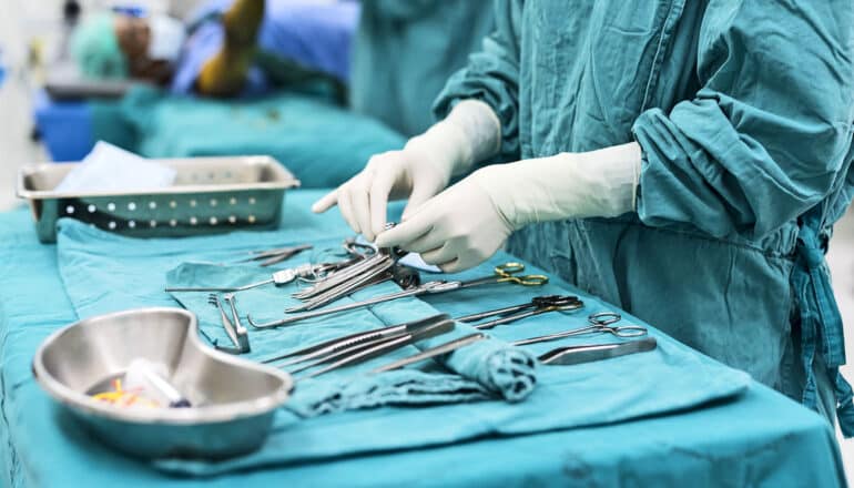 scrub nurse preparing medical equipments for surgery