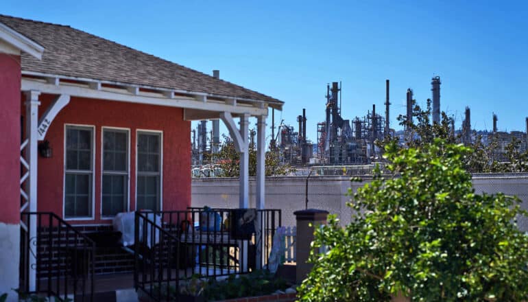 oil refinery behind red house